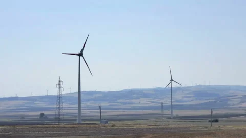 Rotating wind turbines on raw hill, clean energy farm, eco technology Video stock 139549029