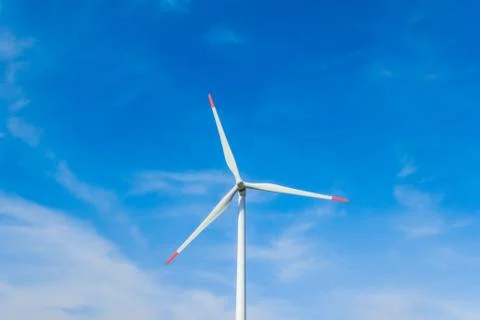 Rotating windmill generating renewable energy with wind power. Sustainability Stock Photos