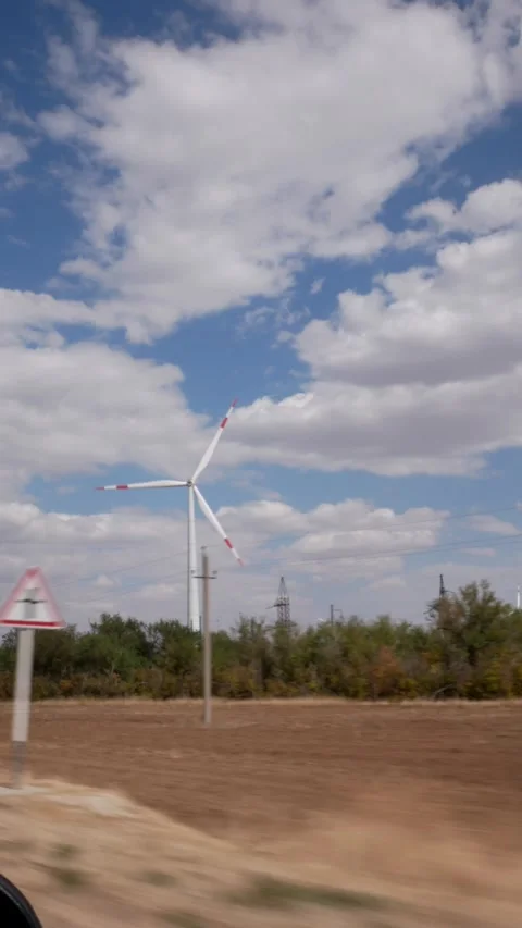 Rotating Windmills and Power Line. Turning wind turbines, moving clouds and and Stock-Footage 285391810