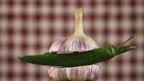 Rotating young garlic with hot pepper inside on a checkered background.Young Stock Footage 248083626