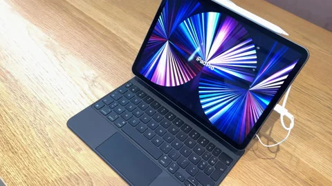 Rotation above Apple Computers iPad pro tablet on the magic keyboard with stand Video stock 219779212