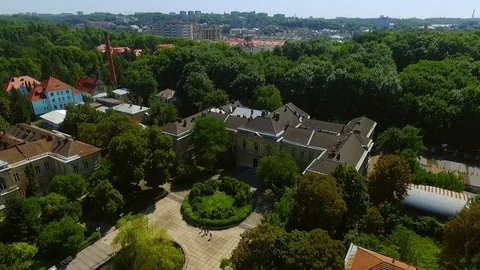Rotation aerial view of gothic old-fashioned estate surrounded with garden in an Video stock 105271019