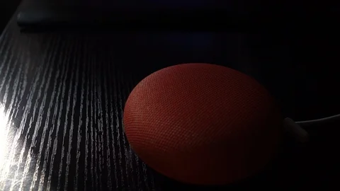 Rotation Around Google Home Mini Lighting Up on Desk Stock Footage 102529396