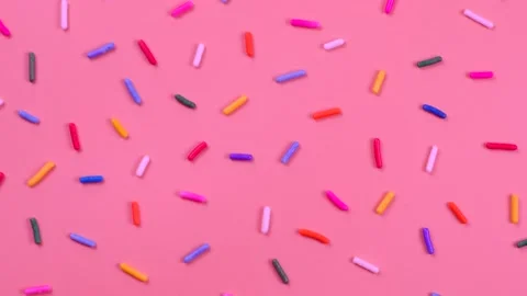 A rotation background of sprinkles for sweets on a pink background.The concept Stock Footage 195930366