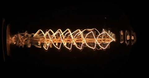 Rotation of the blinking tungsten filament of an old lamp. Texture of a retro Stock Footage 171815755