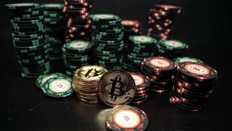 Rotation of the camera over a bitcoin coin against of casino playing chips. Vidéo 179883064