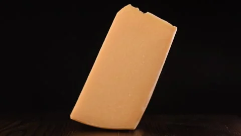 Rotation cheese on black table. Delicious cheese on black background Video stock 147664573