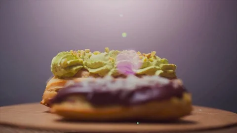 Rotation of chocolate eclair on a wooden board, chocolate eclair on the side Video stock 75436889