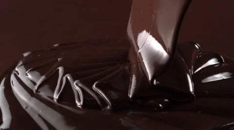 Rotation of chocolate pouring down with swirl in slow motion tabletop High Speed Stock Footage