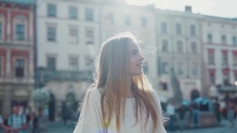 Rotation close up view of charming blonde woman walking down the old city center Stock Footage 112673731