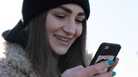 Rotation close up view of pretty young woman smiling to the phone she holds and Video stock 107387816