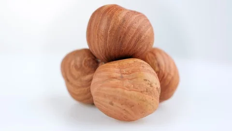 The rotation of a cluster of nuts is close.  Hazelnuts on a white background Stock Footage 118797222