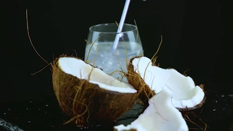 Rotation of coconut shell and white flesh, glass of milk water straw, copy space Stock Footage 156404542