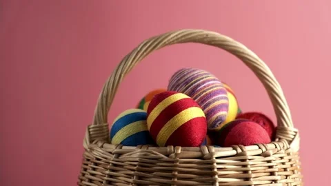 Rotation of colorful easter egg in basket made from threads isolated on pink Video stock 171059300