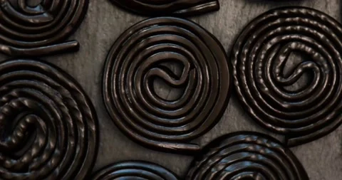Rotation of Flat lay tasty black liquorice candies on black background Stock Footage 195299762
