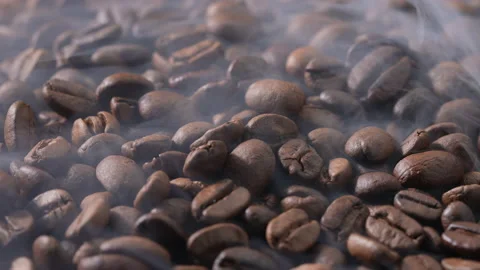 Rotation of Freshly roasted pile of coffee beans with smoke on foreground. Stock-Footage 177538174