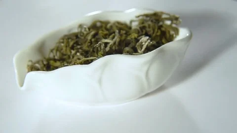 Rotation of green leaf tea in a white bowl Stock-Footage 74450431