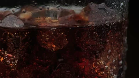 Rotation macro shot  of Cola Bubbles and Ice Cubes in a Glass. Stock Footage 141808387