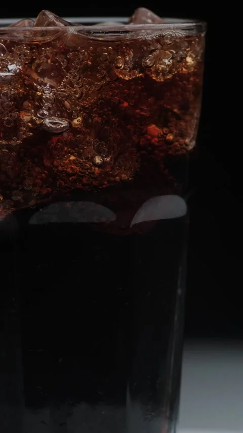 Rotation macro shot  of Cola Bubbles and Ice Cubes in a Glass. Stock Footage 141808390