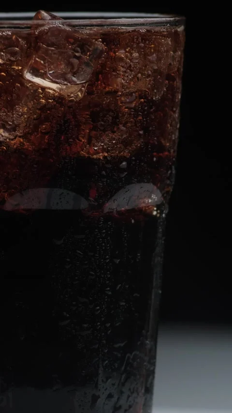 Rotation macro shot  of Cola Bubbles and Ice Cubes in a Glass. 動画素材 141809357
