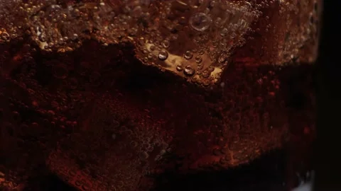 Rotation macro shot  of Cola Bubbles and Ice Cubes in a Glass. Stock Footage 141809490