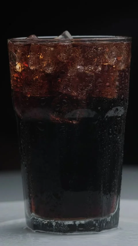 Rotation macro shot  of Cola Bubbles and Ice Cubes in a Glass. Stock Footage 141809634