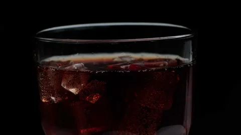 Rotation macro shot  of Cola Bubbles and Ice Cubes in a Glass. Stock Footage 141809819