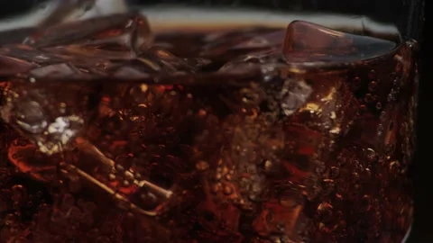 Rotation macro shot  of Cola Bubbles and Ice Cubes in a Glass. Stock Footage 141810033