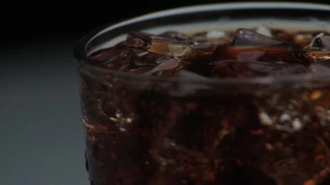 Rotation macro shot  of Cola Bubbles and Ice Cubes in a Glass. Stock Footage 141815814