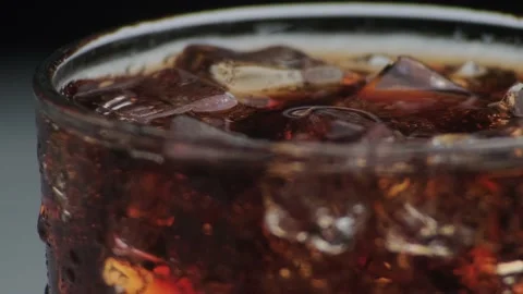 Rotation macro shot  of Cola Bubbles and Ice Cubes in a Glass. Stock Footage 141816823