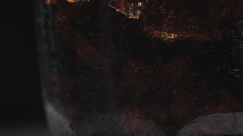 Rotation macro shot of Cola Bubbles and Ice Cubes in a Glass. Stock Footage 141817103