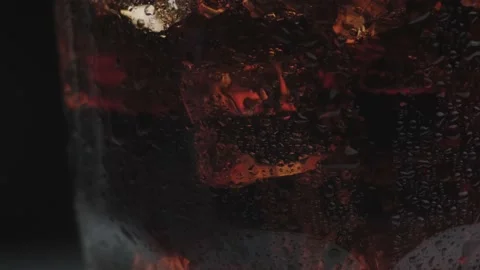 Rotation macro shot  of Cola Bubbles and Ice Cubes in a Glass. 動画素材 141817932