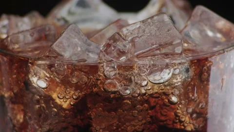Rotation macro shot  of Cola Bubbles and Ice Cubes in a Glass. Stock Footage 141820174