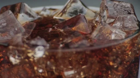 Rotation macro shot  of Cola Bubbles and Ice Cubes in a Glass. Stock Footage 141821253