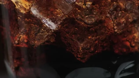 Rotation macro shot  of Cola Bubbles and Ice Cubes in a Glass. Stock Footage 141821339