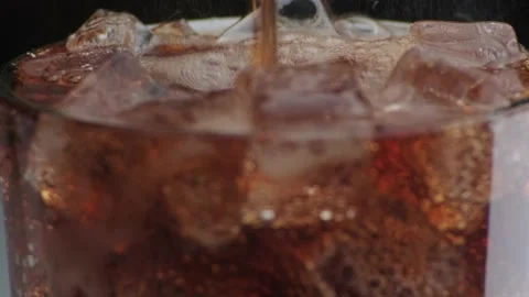 Rotation macro shot  of Cola Bubbles and Ice Cubes in a Glass. Stock Footage 141821663