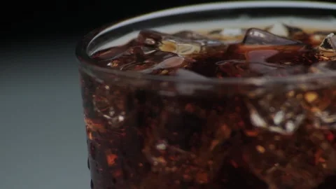 Rotation macro shot  of Cola Bubbles and Ice Cubes in a Glass. Stock Footage 141822870