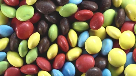 Rotation motion close up of round chocolate candies, dragees in colorful glaze Stock Footage 251194857