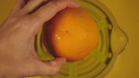 Rotation movement, turn, top view movement. a hand squeezes an orange with a cit 動画素材 224291471