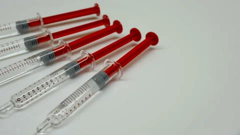 Rotation of new unused syringes on white background, close-up Stock Footage 95440853