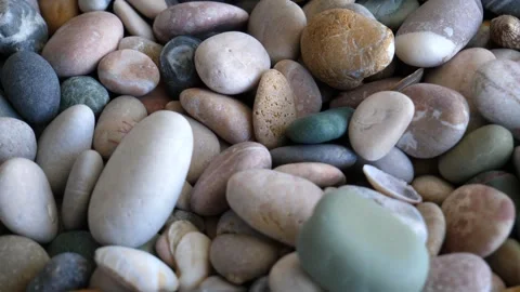 Rotation pattern of round sea stones mixed with small shells 4K video Stock Footage 241305843
