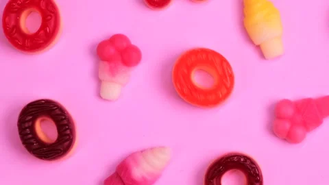 Rotation pink background of various jelly sweets, bears, donuts, candies, on Stock Footage 252031715