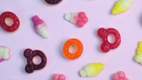 Rotation pink background of various jelly sweets, bears, donuts, candies, on Stock Footage 254052913