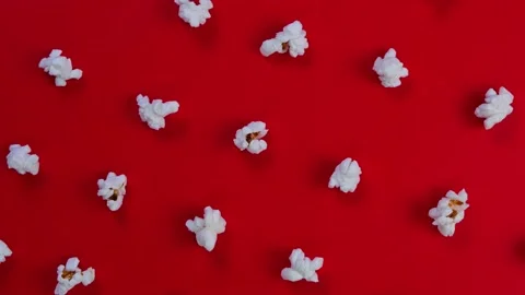 Rotation popcorn on a red background top view close-up , the concept of a cinema Stock Footage 196612136