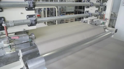 Rotation of a roll of paper on machine-tool or conveyor. Paper is fed onto a Video stock 142301702