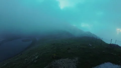 Rotation shot of lake in mountains in clouds Video stock 252072425