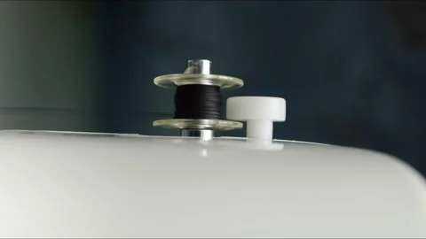Rotation of a small spool for a sewing machine with black thread. Automatic Stock Footage 133430244