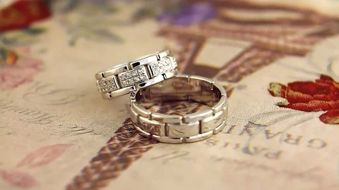Rotation of two silver golden rings Stock Footage 83299176