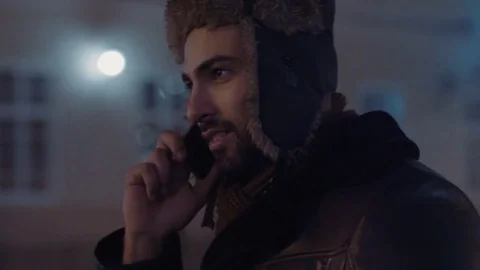 Rotation view of attractive bearded man talking via his smartphone, while Video stock 84652735