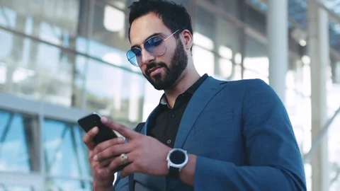 Rotation view of a bearded successful man using his phone by the airport Video stock 76735157